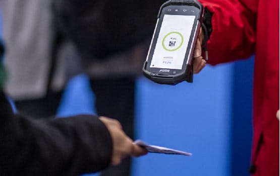 A member of staff scanning a visitor's ticket