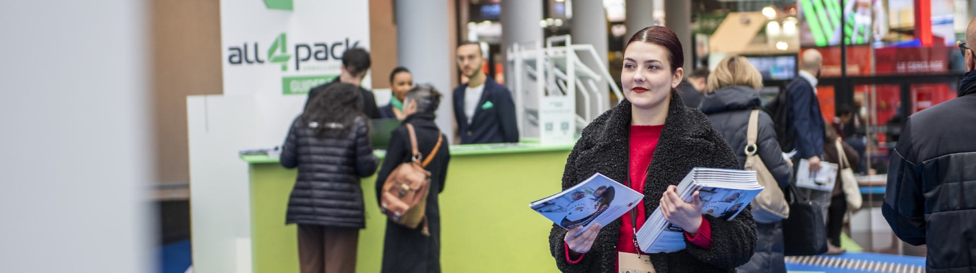 Une femme qui distribue le magazine du salon ALL4PACK EMBALLAGE PARIS